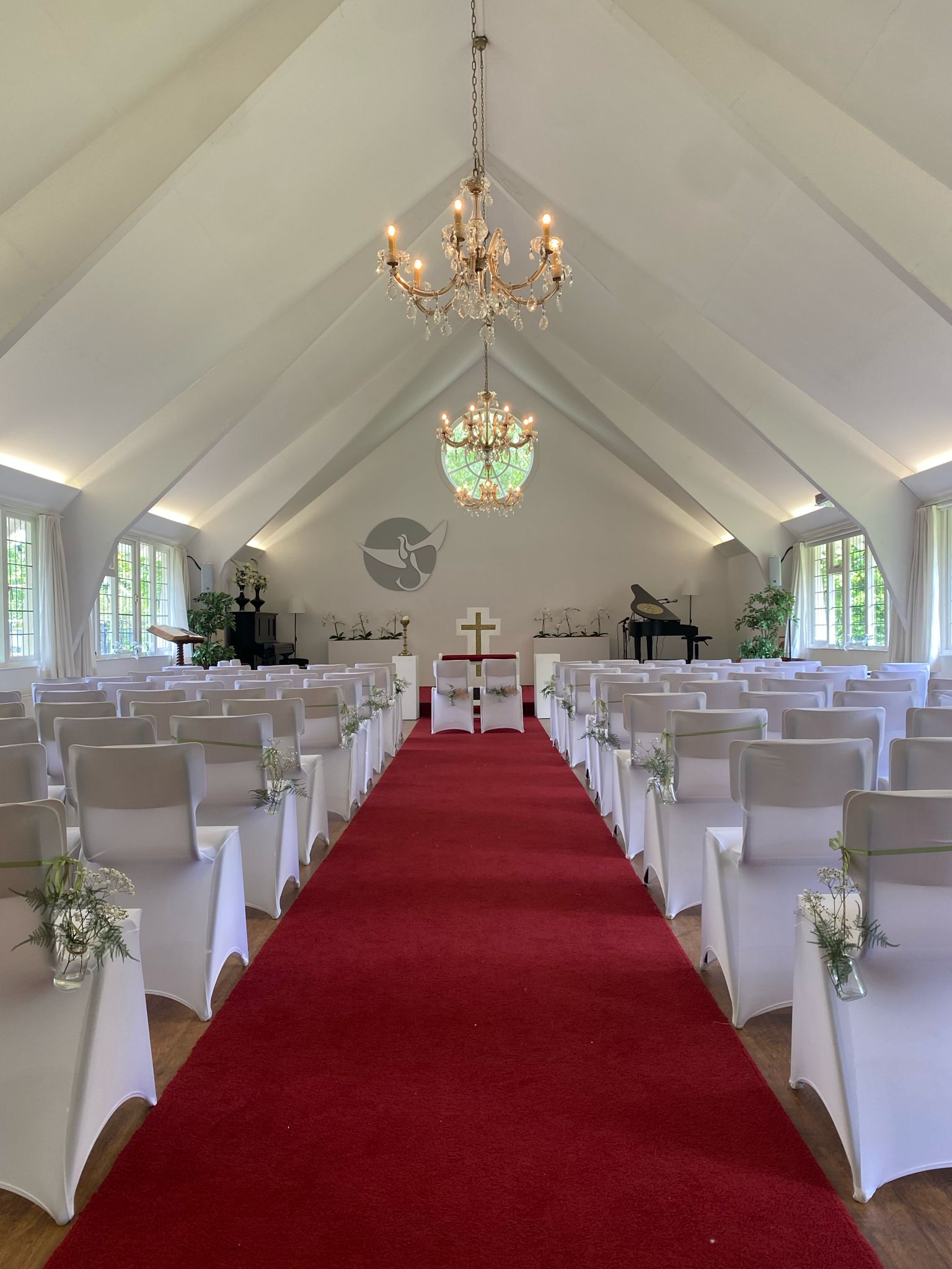 Ceremoniezaal Wit Kerkje met kroonluchters, rode loper, orchideeën en vleugelpiano - professionele faciliteiten voor evenementen